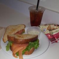 Smoked Salmon Club Sandwich · Smoked salmon, avocado, lettuce, tomato and a lemon dill mayo on wheat toast.