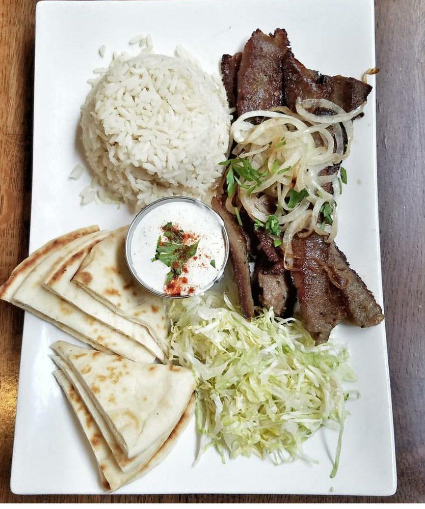 Gyro Plaka · Served with rice, caramelized onion, pita bread, tzatziki sauce and Greek salad.