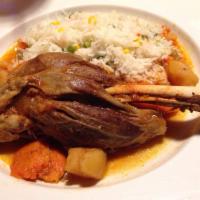 Lamb Shank Entree · Oven-roasted lamb shank served with side of rice and fresh vegetables.