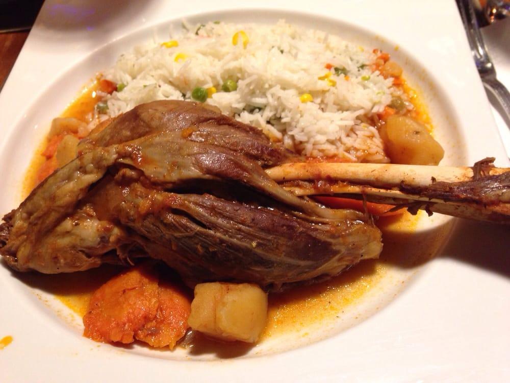 Lamb Shank Entree · Oven-roasted lamb shank served with side of rice and fresh vegetables.