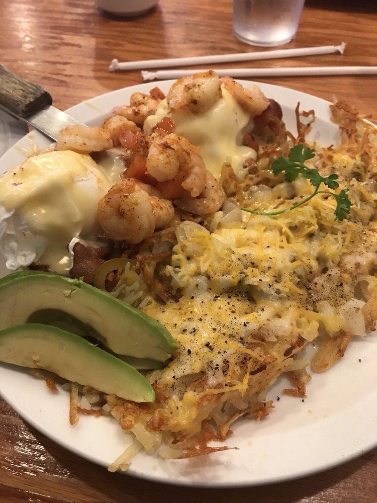 Shrimp Benedict · Grilled shrimp with 2 strips of bacon and poached eggs topped with diced tomatoes and hollandaise atop a toasted English muffin.