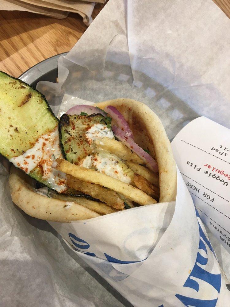 Veggie Pita · Grilled zucchini and mushrooms served on a served on a warm pita bread filled with fries, tomatoes, onions and tzatziki sauce.