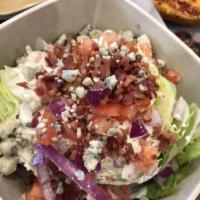 Wedge Salad · Iceberg wedge topped with tomato, red onion, crisp bacon and bleu cheese crumbles. Served wi...