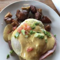 Eggs Benedict · 2 halves of a honey-wheat English muffin topped with over easy eggs, sliced ham, diced tomat...