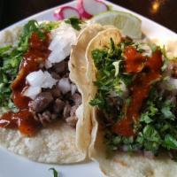 Carne Asada Tacos · 2 steak tacos. Topped with cilantro, onion, and salsa.