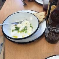 Jocoque · Spreadable yogurt cheese, topped with chopped scallions and olive oil. Served with grilled p...