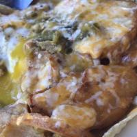Huevos Rancheros · 2 flat corn tortillas topped with 2 eggs, smothered with chile and a blend of Monterey and c...