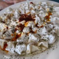 Manti · Anatolian beef dumpling. Steamed dumplings, filled with beef and spices, served with garlic-...