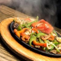 Fajitas · Sizzling fajitas with red and green bell peppers, onions and tomatoes served with sour cream...
