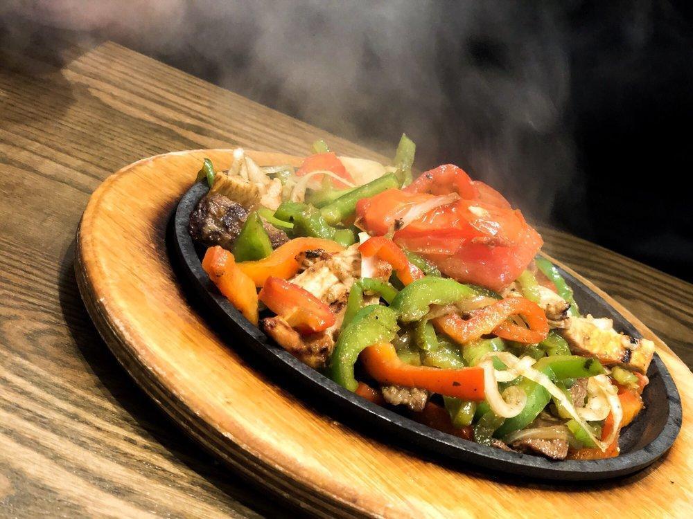 Fajitas · Sizzling fajitas with red and green bell peppers, onions and tomatoes served with sour cream, guacamole, a side of homemade corn or flour tortillas and a choice of rice and black beans or Caesar salad.