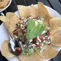 Ceviche Tostada · Fresh fish marinated in lime juice, onions, cilantro and tomatoes served on a crispy corn to...