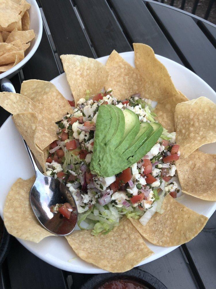 Ceviche Tostada · Fresh fish marinated in lime juice, onions, cilantro and tomatoes served on a crispy corn tortilla with guacamole, fresh chips and sliced avocado.