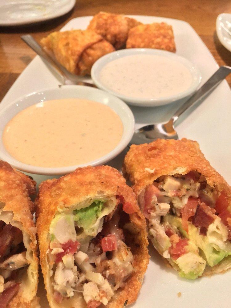 Avocado Club Egg Rolls · Hand-wrapped crispy wonton rolls filled with avocado, chicken, tomato, Monterrey Jack and Nueske's applewood smoked bacon. Served with housemade ranchito sauce and herb ranch.