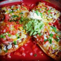 Mexican Pizza · Crispy flour tortilla topped with beans, Monterey Jack cheese and cheddar cheese, tomatoes a...