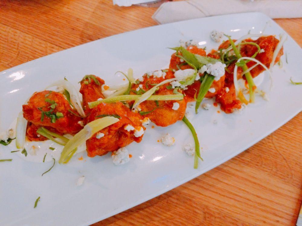 Spicy Buffalo Cauliflower · Fresh cauliflower florets buttermilk-battered and fried to a golden brown, then tossed in housemade Sriracha Buffalo sauce and topped with a salad of celery, cilantro, scallions and Gorgonzola. Vegetarian.