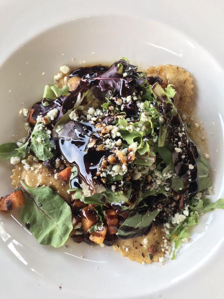 Butternut Squash Ravioli · Our ravioli is filled with blue cheese and cooked with brown sage butter, toped with candied hazelnuts, gorgonzola cheese, Arcadian mixed greens and balsamic reduction.