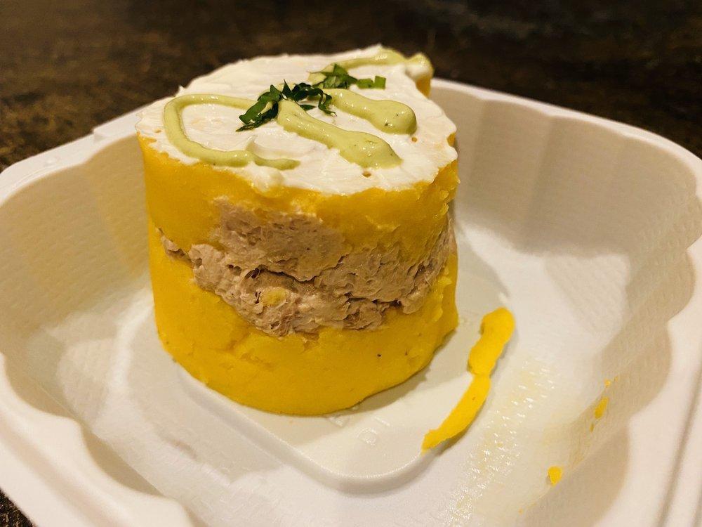 Causa · Two layers of whipped yellow potatoes made with aji amarillo chili, served with a tasty layer of tuna salad in between and topped with our spicy aji verde sauce.