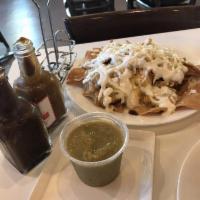 Chilaquiles · Crispy tortillas drenched in red or green salsa with shredded chicken, melted cheese, Mexica...