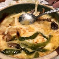 Queso Fundido · Melted mozzarella cheese served with mushrooms, poblano peppers, onions, and warm corn torti...