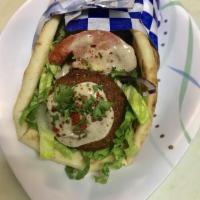 Falafel Pita · Vegetarian. Fried croquettes of ground, herbed garbanzos, served with tahini sauce, lettuce,...