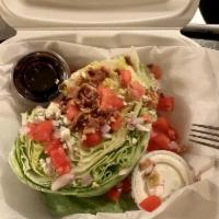 The Wedge Salad · Crisp wedge of iceberg lettuce topped with bleu cheese dressing, diced tomato, diced red oni...