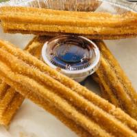 Churros · Traditional Mexican churros filled with cajeta, with a chocolate sauce to dip.