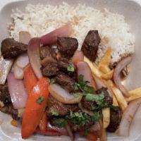 Lomo Saltado · Stir fry combines marinated strips of fillet mignon, with red onions, tomatoes, red wine and...