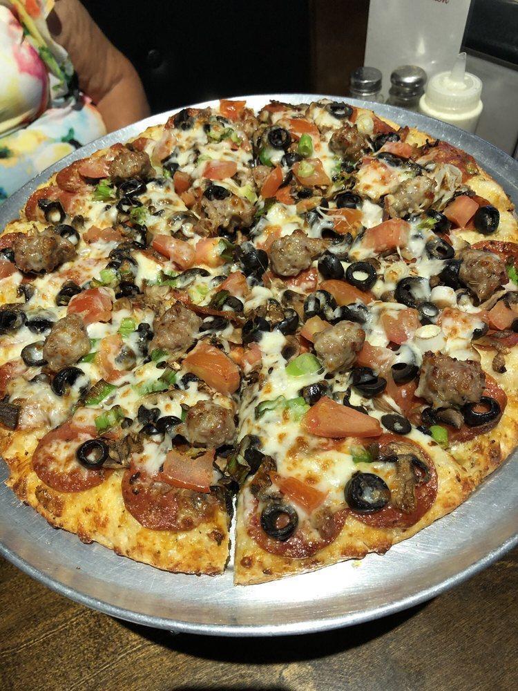 Creamy Garlic Vegetarian Pizza · Rich and creamy garlic sauce and mozzarella cheese with mushrooms, black olives, green onions, broccoli and cooked tomatoes.