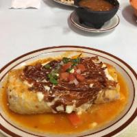 Burrito Suizo · Cecina, steak, al pastor, or chicken. Topped with tomato, lettuce, beans, sour cream, and ch...