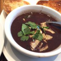 Black Bean Soup · Slow cooked black beans infused with roasted tomatoes & smoked chilis. Served with garlic br...