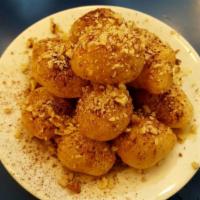 Loukoumades · Fried dough drizzled with honey and sprinkled with walnuts and cinnamon.