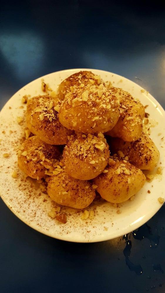 Loukoumades · Fried dough drizzled with honey and sprinkled with walnuts and cinnamon.