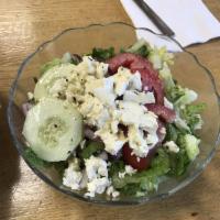 Greek Salad · Romaine lettuce, tomato, onion, feta cheese, cucumber, olives, pepperoncini and grape leaves...