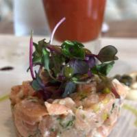 Salmon Tartare · Finely cut salmon marinated with red onions, olive oil, Dijon mustard, aromatics herbs and b...