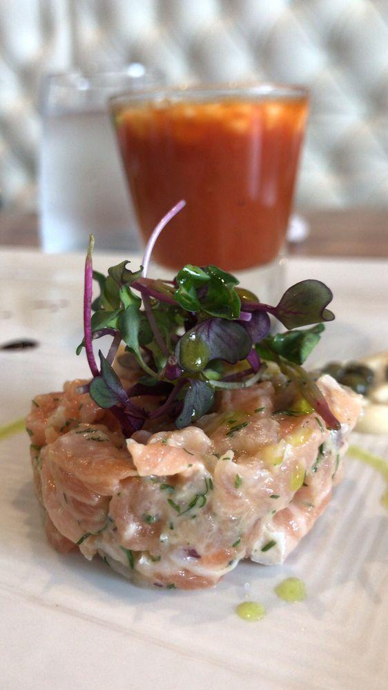 Salmon Tartare · Finely cut salmon marinated with red onions, olive oil, Dijon mustard, aromatics herbs and black olive. Topped with crispy bread and capers mayonnaise.