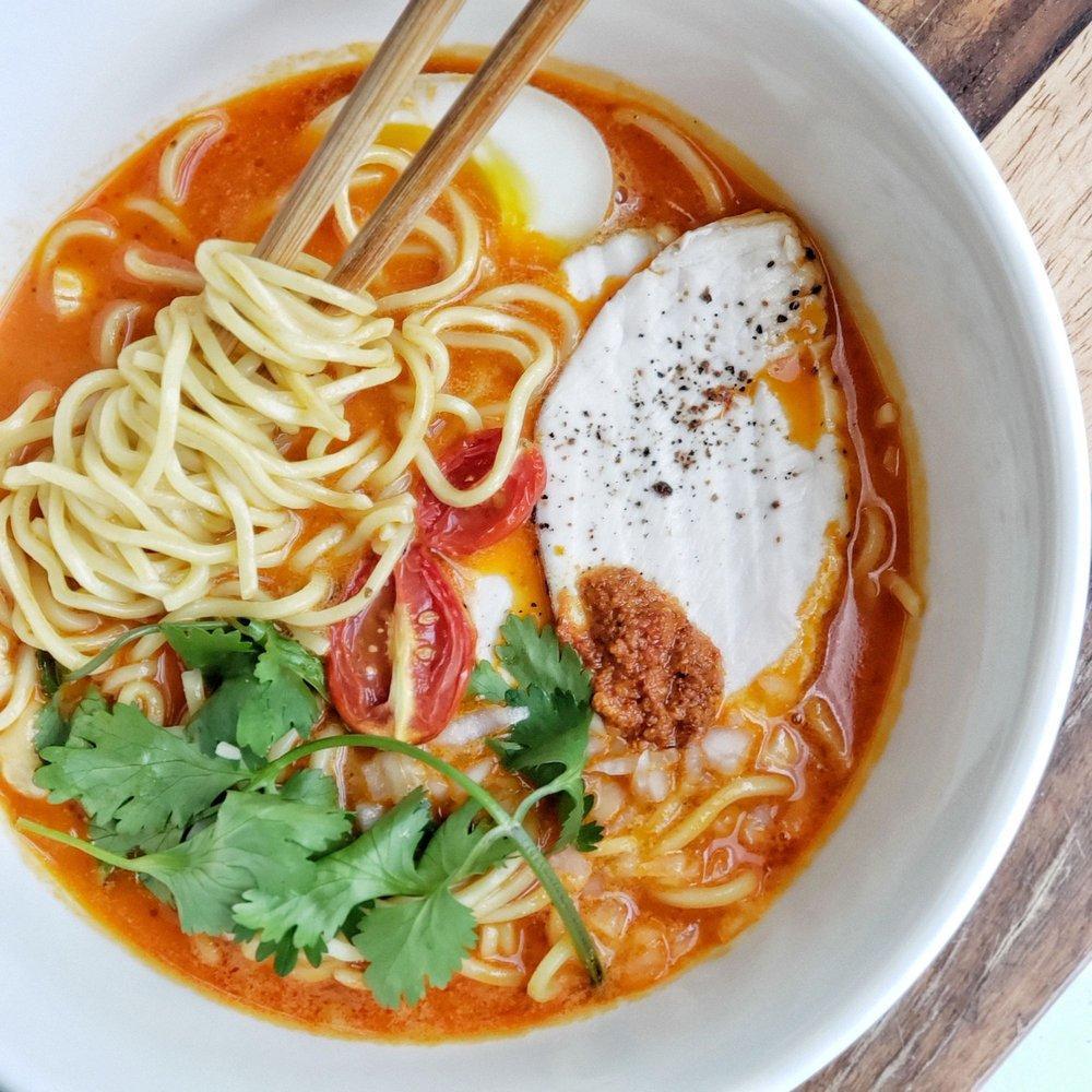 Spicy Paitan Ramen · Our spicy version of our creamy broth ramen with a hint of nuttiness. Comes with cilantro, aji tama, umami egg, cashew nuts, roasted mini tomato, onion, and your choice of protein.