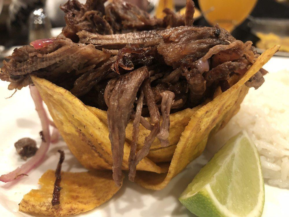 Vaca Frita · Famous crispy seared shredded flank steak, marinated with rumba’s mojo, cooked with red onions.