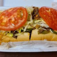 Philly Cheese Steak · Shaved prime rib steak grilled with green peppers and onions on a hoagie roll, topped with m...