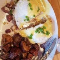 Eggs Benedict · Two halves of a honey-wheat English muffin topped with over easy eggs, sliced ham, diced tom...
