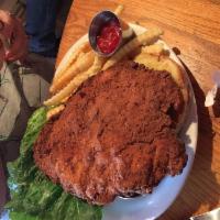 Pork Tenderloin Sandwich · House-made and large enough to hang off its sesame seed bun, this spicy breaded tenderloin i...