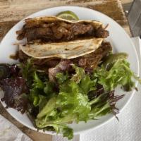 Carne Asada Tacos · 2 soft flour tortillas with seasoned steak, caramelized onions, roasted jalapenos, Monterey ...