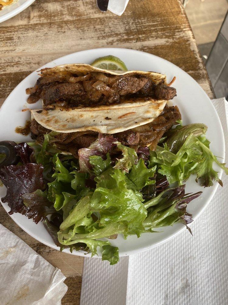 Carne Asada Tacos · 2 soft flour tortillas with seasoned steak, caramelized onions, roasted jalapenos, Monterey Jack cheese. Served with side of greens.