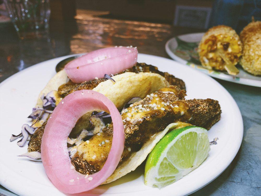 Crispy Chayote Fish Tacos · Hemp and flax seed battered chayote squash, chipotle almond butter, pickled red onion. Spicy. Contains nuts. Gluten free.
