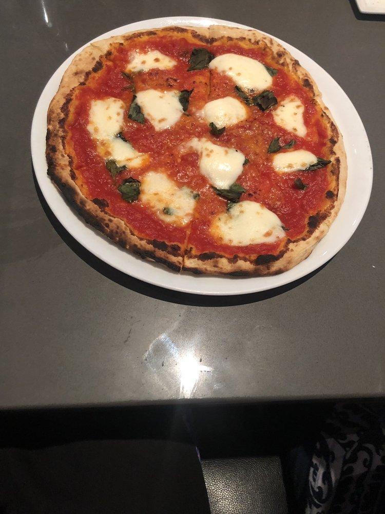 Margherita Pizza · Tomato sauce, buffalo mozzarella and basil. Baked in our brick oven with house-made mozzarella.