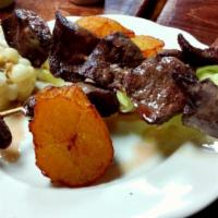 Anticuchos · Classic Peruvian style kabob. Marinated beef heart in rich spices, accompanied with potatoes...
