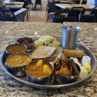 Daily Special Thali · Full meal with 3 curry, 1 dal, rice, roti, appetizer, dessert, fryums, indian pickle, raita/...