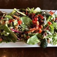 Kale Salad · Fresh baby kale tossed with spiced garbanzo beans, Mama Lil's peppers, kalamata olives, blue...