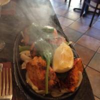 Chicken Tandoori · Bone in Chicken marinated in yogurt and spices, roasted in tandoor oven. Served in sizzling ...