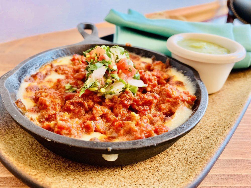 Queso Fundido · Melted cheese with Mexican sauce made of mushrooms or chorizo served with flour tortillas.