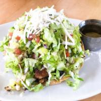 Tostada Salad · Crispy corn tortilla layered with black beans, shredded romaine lettuce tossed with roma tom...